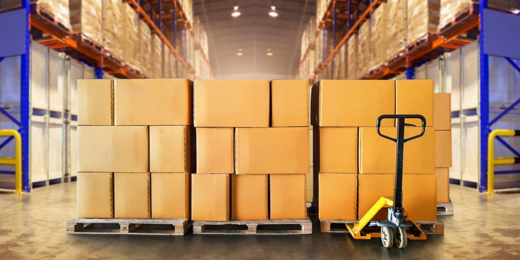 Example of how to stack a pallet with neatly arranged cardboard boxes in a warehouse, featuring a manual pallet jack in the foreground