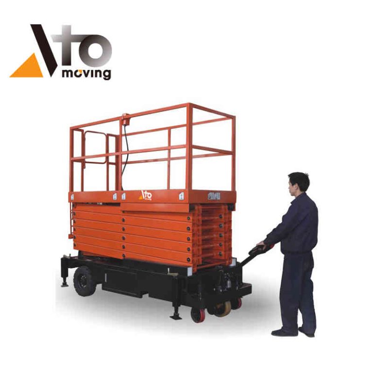 Worker operating a lowered scissor platform lift, designed for safe vertical access, in industrial or construction environments