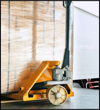 Warehouse worker operating heavy duty pallet jack